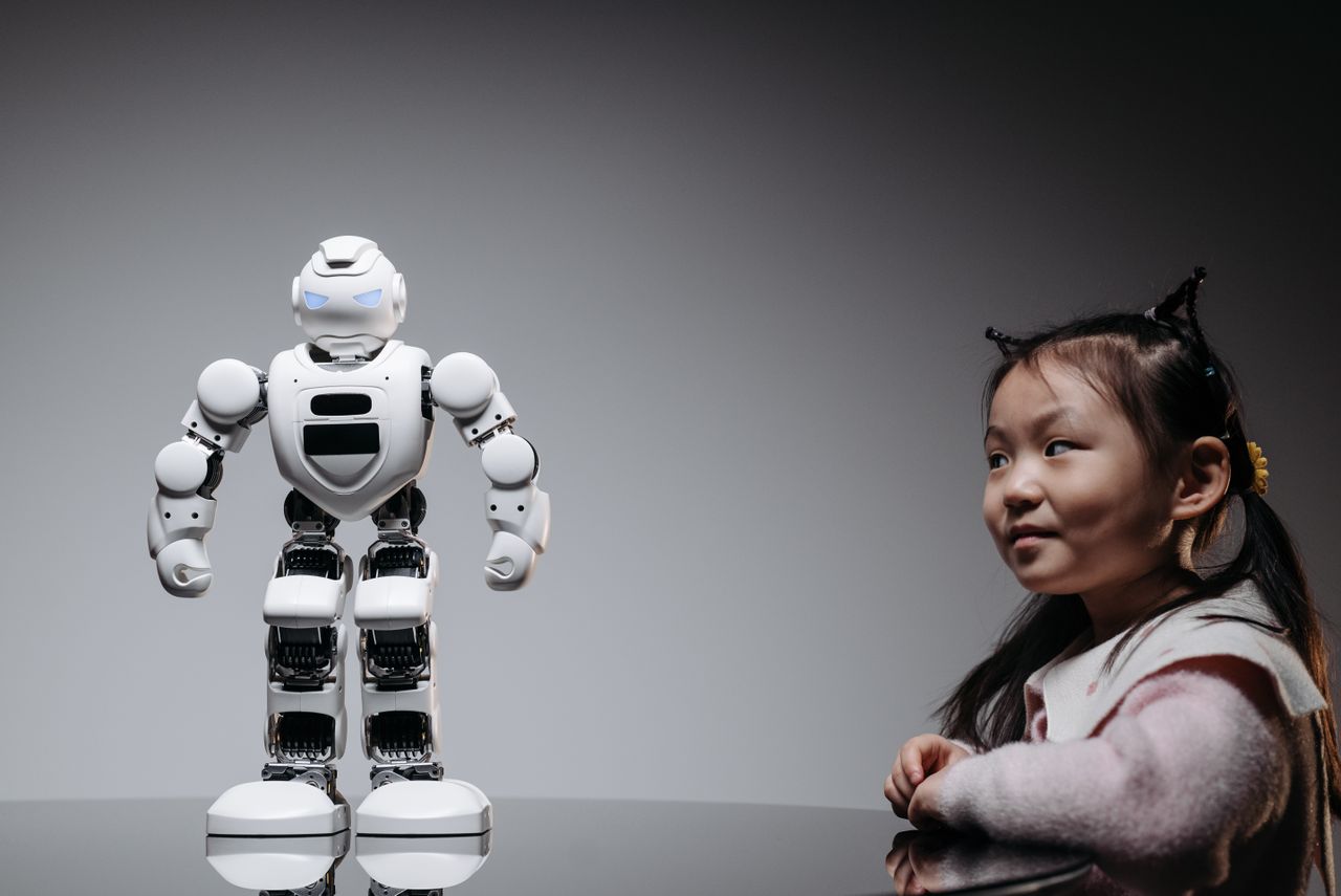 about-02 Young Asian girl interacts with a high-tech toy robot, showcasing innovation and curiosity.